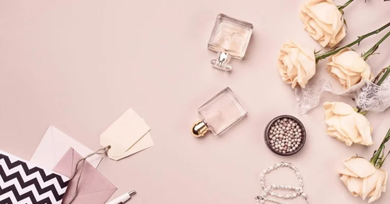 perfumes, flowers,and beads in a pink background